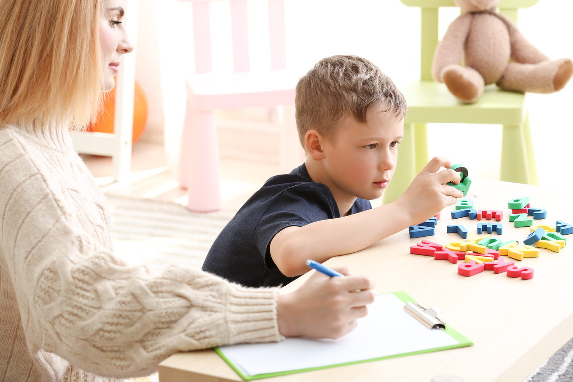 Female Psychologist Working with Boy Suffering from Autistic Disorder